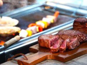 a grill with some meat on a cutting board at 奏の森リゾート　フォレストグランピング in Ito