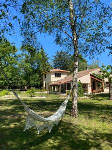 a hammock hanging from a tree in front of a house at Chambre privée à La Figulina in Grayan-et-lʼHôpital