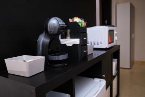 a coffee maker sitting on a table with a microwave at Habitaciones pensadas para ti in Fuengirola