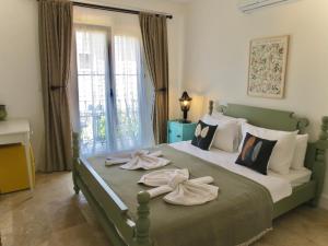 a bedroom with a large bed with towels on it at Fedora Otel Alaçatı in Alaçatı +117 photos