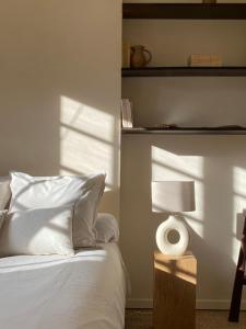 a bedroom with a bed with a lamp and shadows at Chambre privée à La Figulina in Grayan-et-lʼHôpital