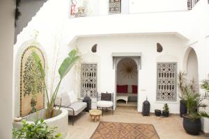 a courtyard in a house with white walls and plants at Riad Dar Wildeve in Marrakech