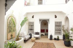 un patio en una casa con paredes y plantas blancas en Riad Dar Wildeve, en Marrakech