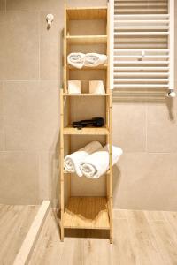 - Baño con toallero de madera y toallas en Prime 11 Apartment in Infinity Beach Resort - parking, en Mamaia