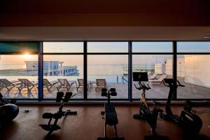un gimnasio con bicicletas estáticas frente a una gran ventana en Prime 11 Apartment in Infinity Beach Resort - parking, en Mamaia