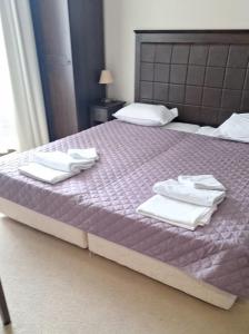 a bedroom with a purple bed with towels on it at Arendo Sea - apartment in Barceló Hotel in Sunny Beach +8 photos