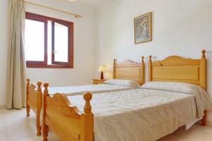 two wooden beds in a bedroom with a window at Villa La Pinta in Santanyi +9 photos