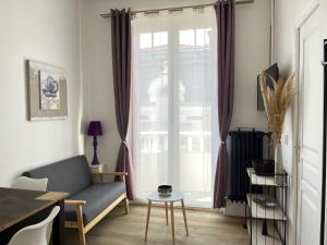 a living room with a couch and a window at Résidence Harmony in Vichy