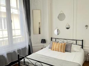 a bedroom with a bed with white walls and a window at Résidence Harmony in Vichy
