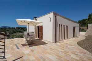 a patio with a white umbrella and a table and chairs at La Vista Azzurra in Lerici