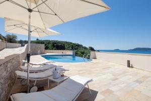 a patio with chairs and an umbrella and a swimming pool at La Vista Azzurra in Lerici