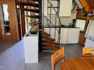 a kitchen with a spiral staircase in a tiny house at Bungalowpark West Friesland in Opmeer