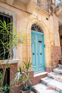 a blue door on the side of a building at Charming Historic Home with Rooftop Views in Senglea