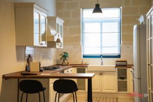 a kitchen with a table and two chairs in it at Historic 2BR Home in Isla with Rooftop Views in Senglea