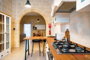 een keuken met een fornuis en een aanrechtblad bij Charming Historic Home with Rooftop Views in Senglea +16 foto's
