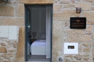a door to a bedroom in a stone building with a sign at Casa d'avó Herminia in Seia