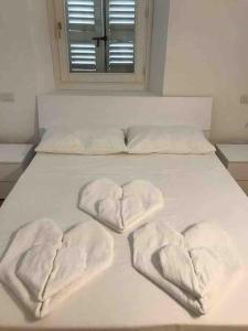 a bed with two hearts shaped towels on it at Lake pool&garden house in Meina