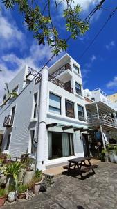 a white building with a picnic table in front of it at La View 麗晨 Homestay in Manzhou
