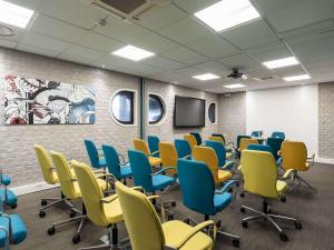 - une salle de conférence avec des chaises et une télévision dans l'établissement Mercure Paris Gare De Lyon TGV, à Paris