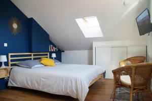 a bedroom with a bed with a blue accent wall at La Résidence des 53 in La Roche-sur-Yon