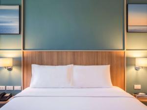 a bedroom with a bed and two lamps and a phone at Ibis Phuket Patong in Patong Beach