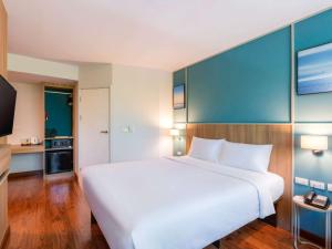 a large white bed in a hotel room at Ibis Phuket Patong in Patong Beach