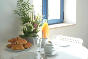a table with two plates of pastries and coffee cups at Centre les sables - jet d'eau - T2 Sauveterre in Les Sables-dʼOlonne