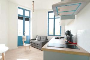 a kitchen with a sink and a couch in a room at Centre les sables - jet d'eau - T2 Sauveterre in Les Sables-dʼOlonne