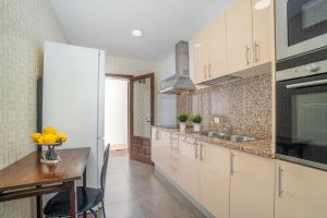 una cucina con un tavolo e un frigorifero bianco di Apart-rent Casa con jardín Pani 0081 a Empuriabrava
