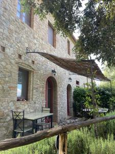 une table et des chaises devant un bâtiment en pierre dans l'établissement Borgo Mommialla Casa dell'artista, à Gambassi Terme