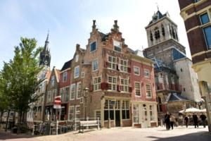 a large building with people walking in front of it at Apartment Havenstraat in Delft