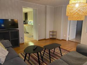 a living room with a couch and two tables at Egen lägenhet på Södermalm nära centrum in Sundsvall