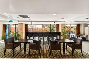 a meeting room with two tables and chairs and windows at Hampton by Hilton Cluj-Napoca in Cluj-Napoca
