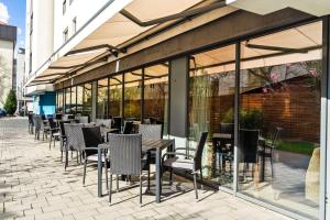 a row of tables and chairs in front of a building at Hampton by Hilton Cluj-Napoca in Cluj-Napoca