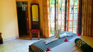 una camera da letto con un letto con fiocchi rossi sopra di Sigiri Thilanka Rest Sigiriya a Sigiriya