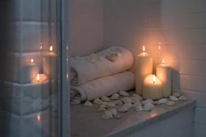 a bathroom with two candles and a pile of towels at Amalfi Luxury House in Amalfi
