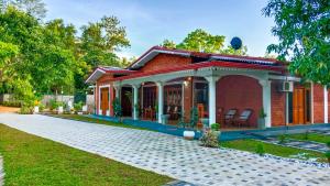 una casa in mattoni rossi con un padiglione di Sigiri Thilanka Rest Sigiriya a Sigiriya
