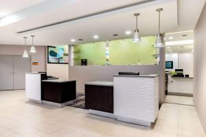 an office lobby with two desks and a large window at La Quinta by Wyndham Indianapolis South in Indianapolis