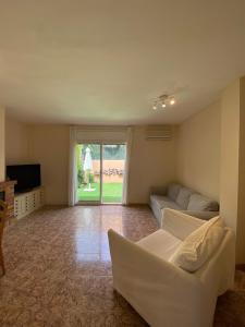 a living room with a white couch and a television at Olive’s Montseny in Breda