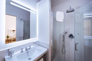 a white bathroom with a sink and a shower at Amalfi Luxury House in Amalfi