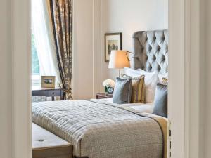 a bedroom with a large bed and a window at Fairmont Hotel Vier Jahreszeiten in Hamburg