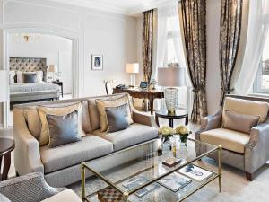 a living room with a couch and a table at Fairmont Hotel Vier Jahreszeiten in Hamburg