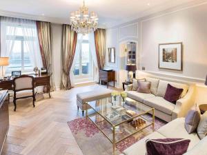 a living room with a couch and a table at Fairmont Hotel Vier Jahreszeiten in Hamburg