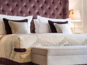 a bedroom with a large bed with a purple headboard at Fairmont Hotel Vier Jahreszeiten in Hamburg