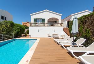 a villa with a swimming pool and lounge chairs at Villa Magnolia by Sonne Villas in Cala Galdana