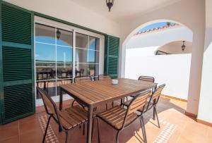 a dining room with a wooden table and chairs at Villa Magnolia by Sonne Villas in Cala Galdana