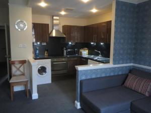 a kitchen with a couch and a washer and dryer at Edinburgh Old Town Apartment in Edinburgh