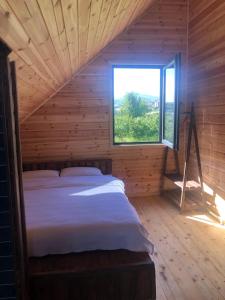 een bed in een houten kamer met een raam bij Trabzon Tosun Bungalov in Trabzon