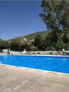 a large blue swimming pool with people standing around it at Mi Descanso in El Bosque