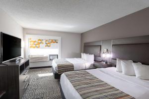 a hotel room with two beds and a flat screen tv at Country Inn & Suites by Radisson, Lake Norman Huntersville, NC in Huntersville